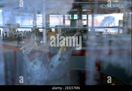 Nesselwang, Deutschland. Dezember 2020. Ungeöffnete Champagnerflaschen stehen an der Talstation der Alpspitzbahn, hinter der Fensterscheibe einer geschlossenen Skibar. Quelle: Karl-Josef Hildenbrand/dpa/Alamy Live News Stockfoto