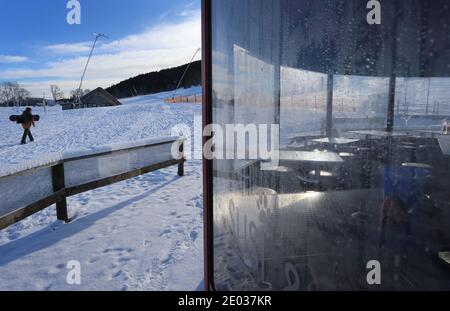 Nesselwang, Deutschland. Dezember 2020. Ein Snowboarder geht an einer geschlossenen Skibar an der Talstation der Alpspitzbahn vorbei. Quelle: Karl-Josef Hildenbrand/dpa/Alamy Live News Stockfoto