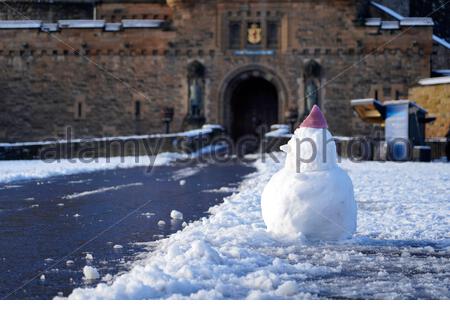 Edinburgh, Schottland, Großbritannien. Dezember 2020. Über Nacht Schnee in der Innenstadt mit der Burg Esplanade mit Schnee bedeckt und ein Schneemann am Schloss Eingang. Kredit: Craig Brown/Alamy Live Nachrichten Stockfoto