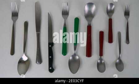 Metallbesteck, Löffel, Gabeln, Messer flach auf weißem Hintergrund, Küchenzubehör, Draufsicht Stockfoto