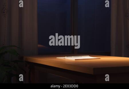 Offenes Notebook in Lampe Licht auf Schreibtisch vor Fenster, Nacht zu Hause Büro Arbeitsplatz Stockfoto