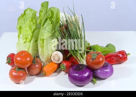 Verschiedene bunte Gemüse: Zwiebeln, Tomaten, Karotten, Salat, grüner Pfeffer, Frühlingszwiebeln Stockfoto