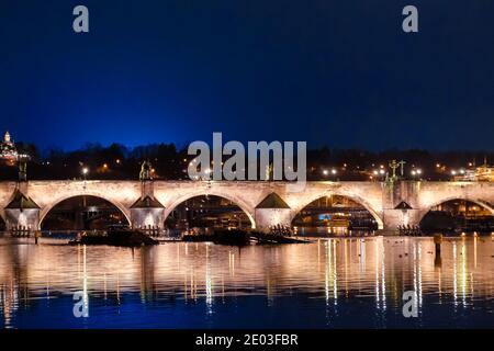 Panoramablick auf die Karlsbrücke bei Nacht mit Spiegelung der Lichter in Fluss Moldau, Prag, Tschechische Republik Stockfoto