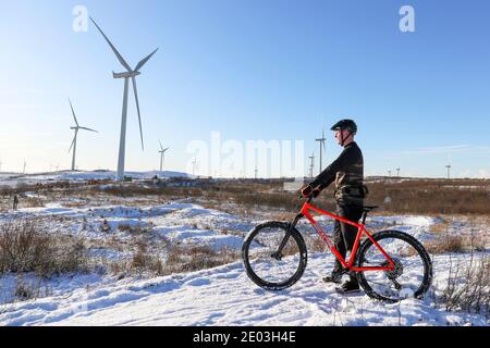 Whitelee Windfarm, Eaglesham Moor, in der Nähe von Glasgow, Großbritannien. Nach einem heftigen Schneefall über Nacht gingen viele Menschen auf die Zufahrtsstraßen zur Whitelee Windfarm, der größten in Europa, um sich zu bewegen und trotzdem eine sichere soziale Distanzierung zu bewahren. Whitelee liegt auf der Südseite der Stadt Glasgow am Rande von Eaglesham Moor und ist der Standort für 215 Windenergieanlagen. Kredit: Findlay/Alamy Live Nachrichten Stockfoto