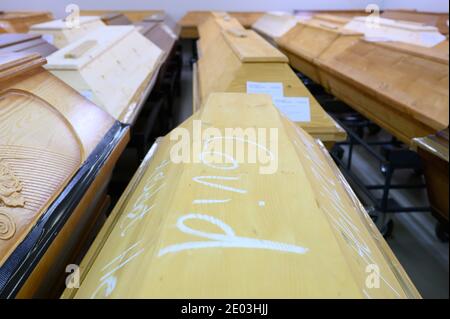 Dresden, Deutschland. Dezember 2020. In Kreide steht "Covid" auf einem Sarg, in dem ein Verstorbener, der an oder mit dem Coronavirus gestorben ist, sich mit anderen Särgen im Krematorium Dresden-Tolkewitz abkühlt. Das Krematorium hat aufgrund der hohen Übersterblichkeit bei der Corona-Pandemie die Kapazitätsgrenze erreicht und ist nun auf die Hilfe anderer Krematorien angewiesen. Quelle: Sebastian Kahnert/dpa-Zentralbild/dpa/Alamy Live News Stockfoto