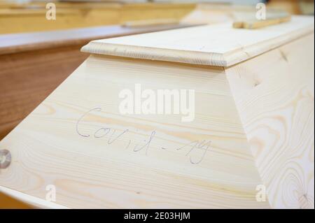 Dresden, Deutschland. Dezember 2020. Im Kugelschreiber steht 'Covid-19' auf einem Sarg mit einem Verstorbenen, der an oder mit dem Coronavirus gestorben ist, der sich mit anderen Särgen im Krematorium Dresden-Tolkewitz in der Kälte befindet. Das Krematorium hat aufgrund der hohen Übersterblichkeit bei der Corona-Pandemie die Kapazitätsgrenze erreicht und ist nun auf die Hilfe anderer Krematorien angewiesen. Quelle: Sebastian Kahnert/dpa-Zentralbild/dpa/Alamy Live News Stockfoto