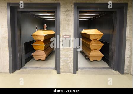 Dresden, Deutschland. Dezember 2020. Claus-Dieter Turra, Kremator, steht mit Särgen in einem Aufzug im Krematorium Dresden-Tolkewitz. Das Krematorium hat aufgrund der hohen Übersterblichkeit bei der Corona-Pandemie die Kapazitätsgrenze erreicht und ist nun auf die Hilfe anderer Krematorien angewiesen. Quelle: Sebastian Kahnert/dpa-Zentralbild/dpa/Alamy Live News Stockfoto