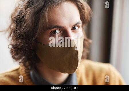 Nahaufnahme eines jungen, hübschen Mannes in Maske, der die Kamera anschaut Stockfoto