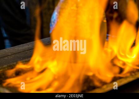 Verschwommener Hintergrund des traditionellen türkischen Testi Kebab, der in Tontopf über dem Feuer auf dem Tisch gekocht wird, Istanbul, Türkei Stockfoto