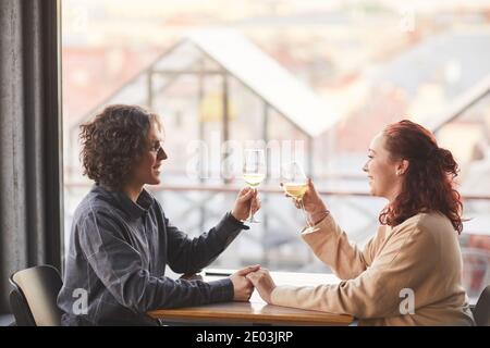 Junges Paar haben romantische Datum in dem Restaurant sie sitzen Am Tisch mit Gläsern Champagner Stockfoto