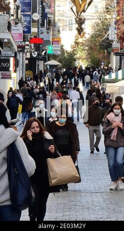 Menschenmenge mit Gesichtsmasken auf einer Einkaufsstraße in Athen, Griechenland Stockfoto
