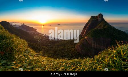 Panoramablick auf Sonnenaufgang in Rio de Janeiro, Pedra da Gavea, Sao Conrado Beach und Two Brothers Mountain mit Favela Rocinha Stockfoto