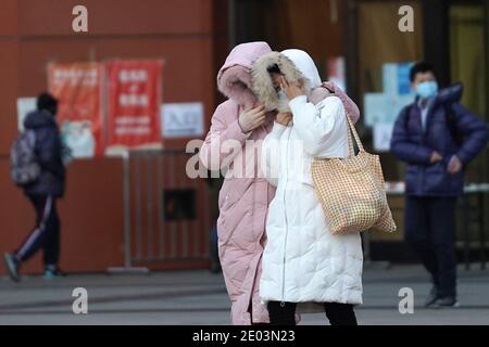 (201229) -- PEKING, 29. Dezember 2020 (Xinhua) -- zwei Fußgänger gehen auf einer Straße im Chaoyang Bezirk, Peking, Hauptstadt von China, 29. Dezember 2020. Chinas meteorologische Behörde hat am Dienstag eine orangene Warnung erneuert, die zweithöchste in einem vierstufigen Warnsystem, für eine kalte Welle, da eine starke Kaltfront seit Montag über die meisten Teile von Zentral- und Ostchina hinwegfegt. (Xinhua/Ju Huanzong) Stockfoto