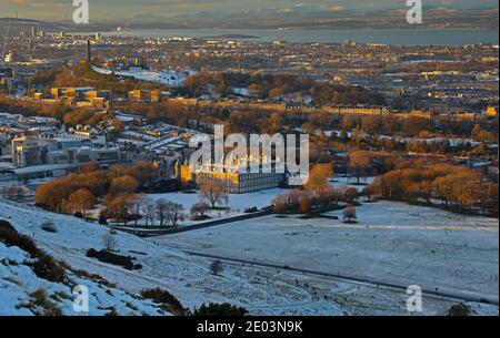 Edinburgh, Schottland, Großbritannien. 29 Dezember 2020. Perfekter Wintertag, beginnend mit einer Schneedecke über der Stadt, die es den Menschen ermöglicht, die Natur zu genießen und endet mit einem schönen warmen Sonnenuntergang, um den Tag zu beenden. Im Bild: Holyrood Park mit Holyrood Palace in der Mitte, Blick auf Calton Hill und die Küste von Fife in der Ferne. Quelle: Arch White/Alamy Live News. Stockfoto