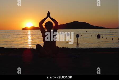 Lemnos Griechenland 15 September 2017 Yoga bei Sonnenuntergang am Plati Beach, Myrina, Lemnos Insel auf den griechischen Inseln mit Blick auf Loutra im Hintergrund Stockfoto