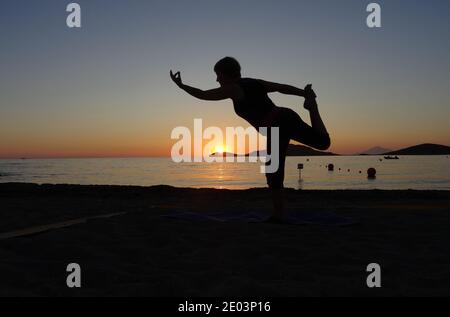Lemnos Griechenland 15 September 2017 Yoga bei Sonnenuntergang am Plati Beach, Myrina, Lemnos Insel auf den griechischen Inseln mit Blick auf Loutra im Hintergrund Stockfoto