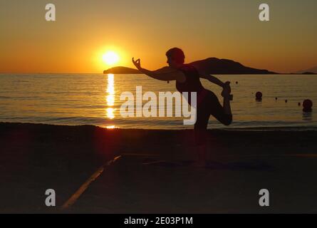 Lemnos Griechenland 15 September 2017 Yoga bei Sonnenuntergang am Plati Beach, Myrina, Lemnos Insel auf den griechischen Inseln mit Blick auf Loutra im Hintergrund Stockfoto