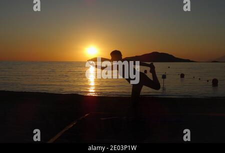 Lemnos Griechenland 15 September 2017 Yoga bei Sonnenuntergang am Plati Beach, Myrina, Lemnos Insel auf den griechischen Inseln mit Blick auf Loutra im Hintergrund Stockfoto