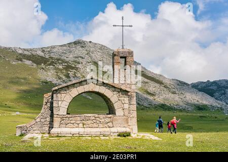 Familie von Wanderern in der Ermita del Pastor, Parque Nacional de los Picos de Europa, Asturien, Spanien. Kapelle des Guten Hirten, Zinnen Europas Nati Stockfoto