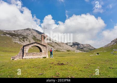 Wanderer in der Ermita del Pastor, Parque Nacional de los Picos de Europa, Asturien, Spanien. Kapelle des Guten Hirten, Nationalpark Peaks of Europe. Stockfoto