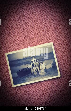 1949 Foto von jungen Frauen mit Rucksäcken bei Derwentwater mit Ruderboot auf texturiertem Hintergrund. Konzept der Freundschaft, Abenteuer, Nostalgie Stockfoto