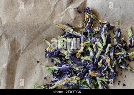 Selektiver Fokus topview von Anchan Blume Kräutertee Clitoria ternatea, auf einem Blatt Kraftpapier. Foto mit negativem Raum. Stockfoto