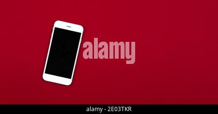 Weißes leeres Smartphone Mockup Foto auf rotem isoliertem Hintergrund mit Kopierplatz, Draufsicht. Hochwertige Fotos Stockfoto