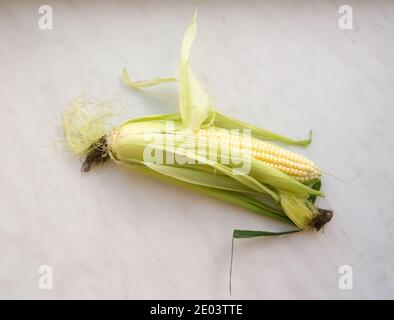 Die gelbe Natur Mais auf einem Marmor Hintergrund. Stockfoto