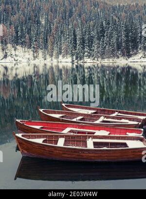 Schneebedeckte rote Boote auf dem Bergsee Misurina Italien Dolomiten Stockfoto