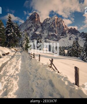 Passo delle Erbe Dolomiten Südtirol Südtirol Südtirol Italien Berg Weg im Schnee mit Holzzaun auf der rechten Seite Stockfoto