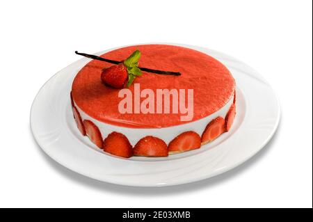 Käsekuchen mit Erdbeeren, ganze Torte mit roter Erdbeercreme mit Vanilleschote und Minzblättern in Teller isoliert auf weißem Hintergrund bedeckt Stockfoto