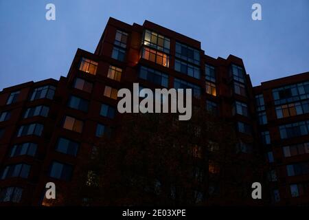 Ein launischer, beängstigender Blick auf ein sich in der Dämmerung aufbahnendes Apartmentgebäude mit einem bewölkten, grauen Himmel. In Arlington, Virginia. Stockfoto