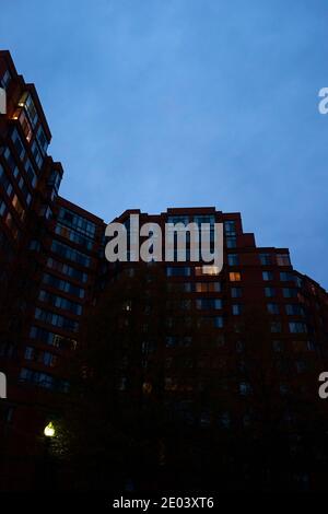 Ein launischer, beängstigender Blick auf ein sich in der Dämmerung aufbahnendes Apartmentgebäude mit einem bewölkten, grauen Himmel. In Arlington, Virginia. Stockfoto