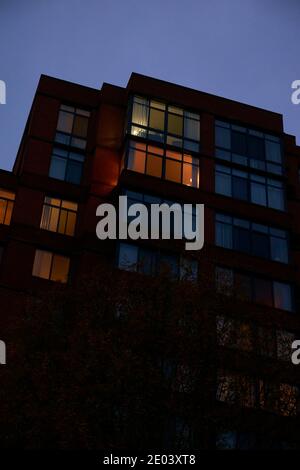 Ein launischer, beängstigender Blick auf ein sich in der Dämmerung aufbahnendes Apartmentgebäude mit einem bewölkten, grauen Himmel. In Arlington, Virginia. Stockfoto