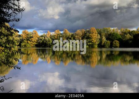 Herbst Farben über den See in Barnwell Country Park, Oundle, Northamptonshire, England, Großbritannien Stockfoto