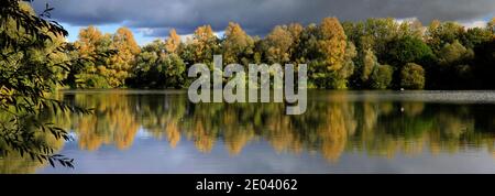 Herbst Farben über den See in Barnwell Country Park, Oundle, Northamptonshire, England, Großbritannien Stockfoto