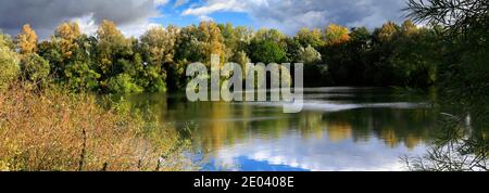 Herbst Farben über den See in Barnwell Country Park, Oundle, Northamptonshire, England, Großbritannien Stockfoto