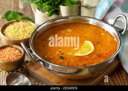 Türkische Küche. Traditionelle Suppe mit Reis, Linsen und Minze auf einem rustikalen Tisch. Stockfoto