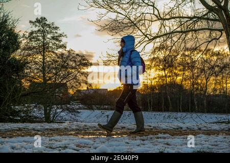 Kidderminster, Großbritannien. Dezember 2020. UK Wetter: Mit einem zweiten Tag Schneeschauer über Worcestershire, der Tag endet mit einem atemberaubenden Winter Sonnenuntergang geben einen goldenen Glanz für Wanderer, warm eingewickelt, genießen die winterlichen Bedingungen in ihrem lokalen Landpark. Kredit: Lee Hudson/Alamy Live Nachrichten. Stockfoto