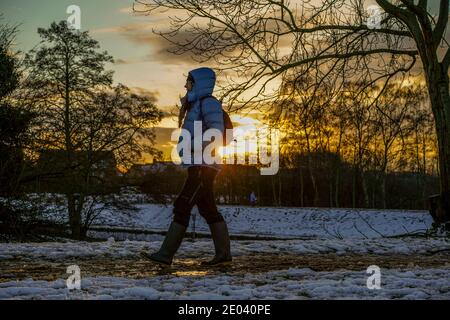 Kidderminster, Großbritannien. Dezember 2020. UK Wetter: Mit einem zweiten Tag Schneeschauer über Worcestershire, der Tag endet mit einem atemberaubenden Winter Sonnenuntergang geben einen goldenen Glanz für Wanderer, warm eingewickelt, genießen die winterlichen Bedingungen in ihrem lokalen Landpark. Kredit: Lee Hudson/Alamy Live Nachrichten. Stockfoto