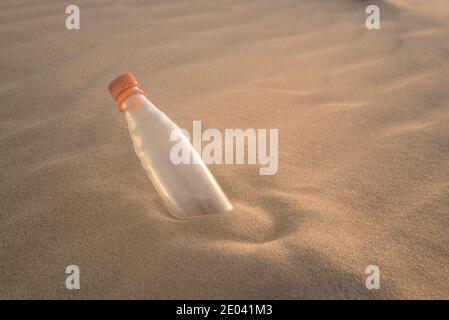Eine Flasche halb im Sand vergraben Stockfoto