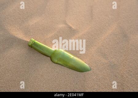 Eine Flasche halb im Sand vergraben Stockfoto