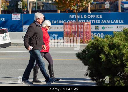 Ältere Paare unter Spaziergängen auf der Straße, die Hände halten. White Rock, BC. Konzept Foto Beziehung. Stockfoto