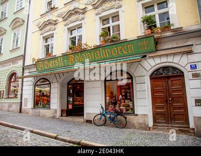 Altmodisches Schild zeigt die barocke Architektur von Gerstl Kolonialwaren, einem Lebensmittelgeschäft am Residenzplatz 13, Passau, Bayern, Deutschland. Stockfoto