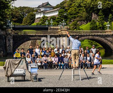Gruppenfotograf fordert Aufmerksamkeit vor dem Japanischen Kaiserpalast. Fotoshooting vor dem Tenno Palast in Chiyoda (Tokio), Japan Stockfoto