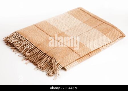 Warme braune Alpakawolle oder Kaschmirdecke isoliert auf weißem Hintergrund. Beige, braun kariert Wollstoff für Haus-Design. Stockfoto
