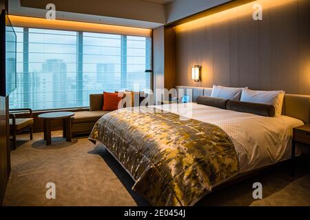 Interieur des Okura Hotels in Tokio, Minato, Japan. Zimmer mit Aussicht. Im Stil traditioneller japanischer Wohnzimmer. Luftig und hell. Die Fensterfront verläuft über die gesamte Länge des Wohnzimmers Stockfoto