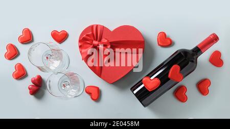 Valentinstag-Set für die Party von Rotwein und Weingläser und Herz Geschenk auf blauem Hintergrund. Blick von oben. Flach liegend. Romantische Grußkarte. Stockfoto