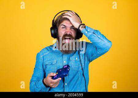 oh nein Konsole Controller Joystick. Gaming in Kopfhörern. Reifen Mann Gamer spielen Computerspiele. Kerl mit Bart spielen Videospiele. Brutal kaukasischen Hipster mit Schnurrbart. Entspannen Sie sich zu Hause. Stockfoto