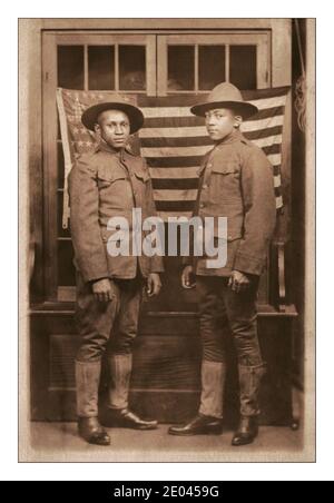 Propaganda-Foto des 1. Weltkrieges, das den Beitrag schwarzer Afroamerikaner zum Ersten Weltkrieg zeigt.zwei nicht identifizierte afroamerikanische Soldaten in Uniformen und Wahlkampfhüten, die vor der amerikanischen Flagge des 1. Weltkrieges 1918 [zwischen 1917 und 1918] standen. Vereinigte Staaten.--Armee--Menschen--1910-1920 Weltkrieg, 1914-1918--Militärpersonal--amerikanische Afroamerikaner--Militärdienst--1910-1920 - Soldaten--Amerikaner--1910-1920 Militäruniformen--Amerikaner--1910-1920 Flaggen--Amerikaner--1910-1920 Gruppenportraits--1910-1920. Fotopostkarten--1910-1920. Fotodrucke--1910-1920. Porträts Stockfoto